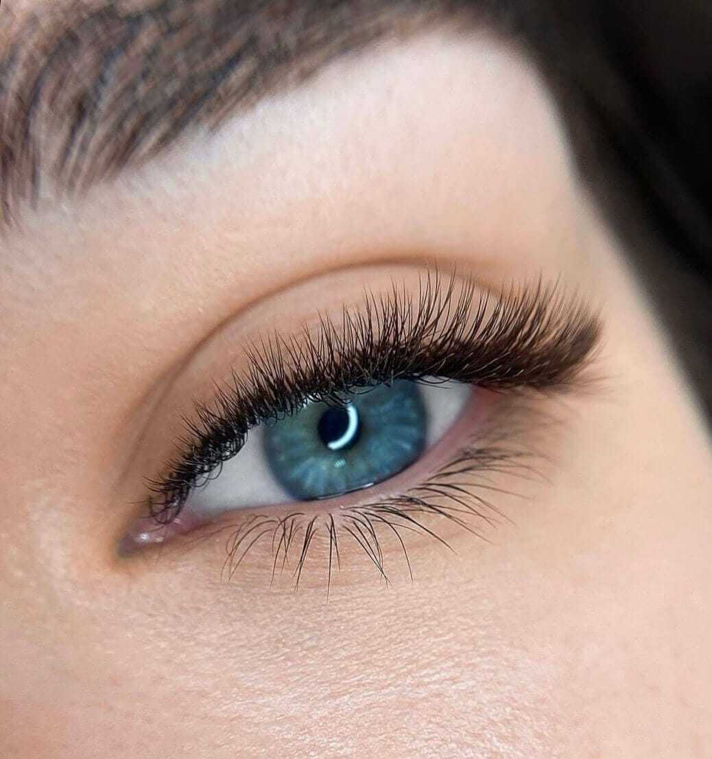 Close-up of a blue eye with long eyelashes and eyebrow detail.