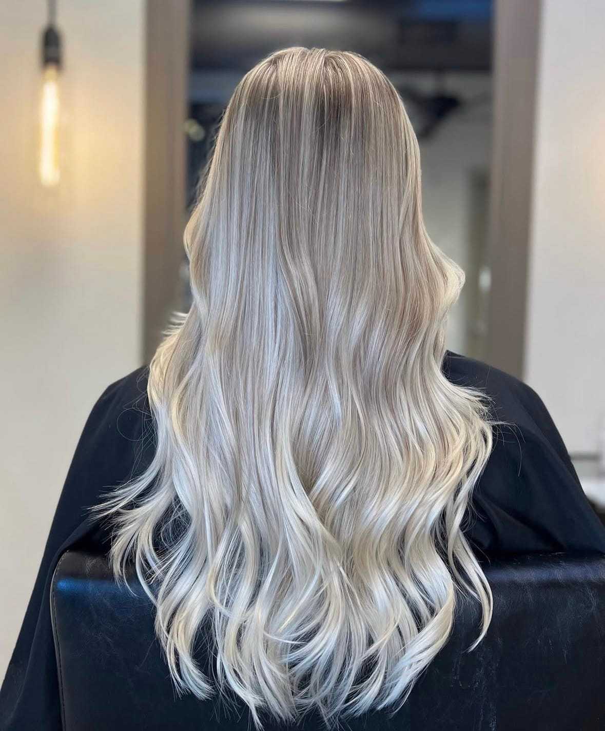 Long, wavy, platinum blonde hair styled in a salon setting.