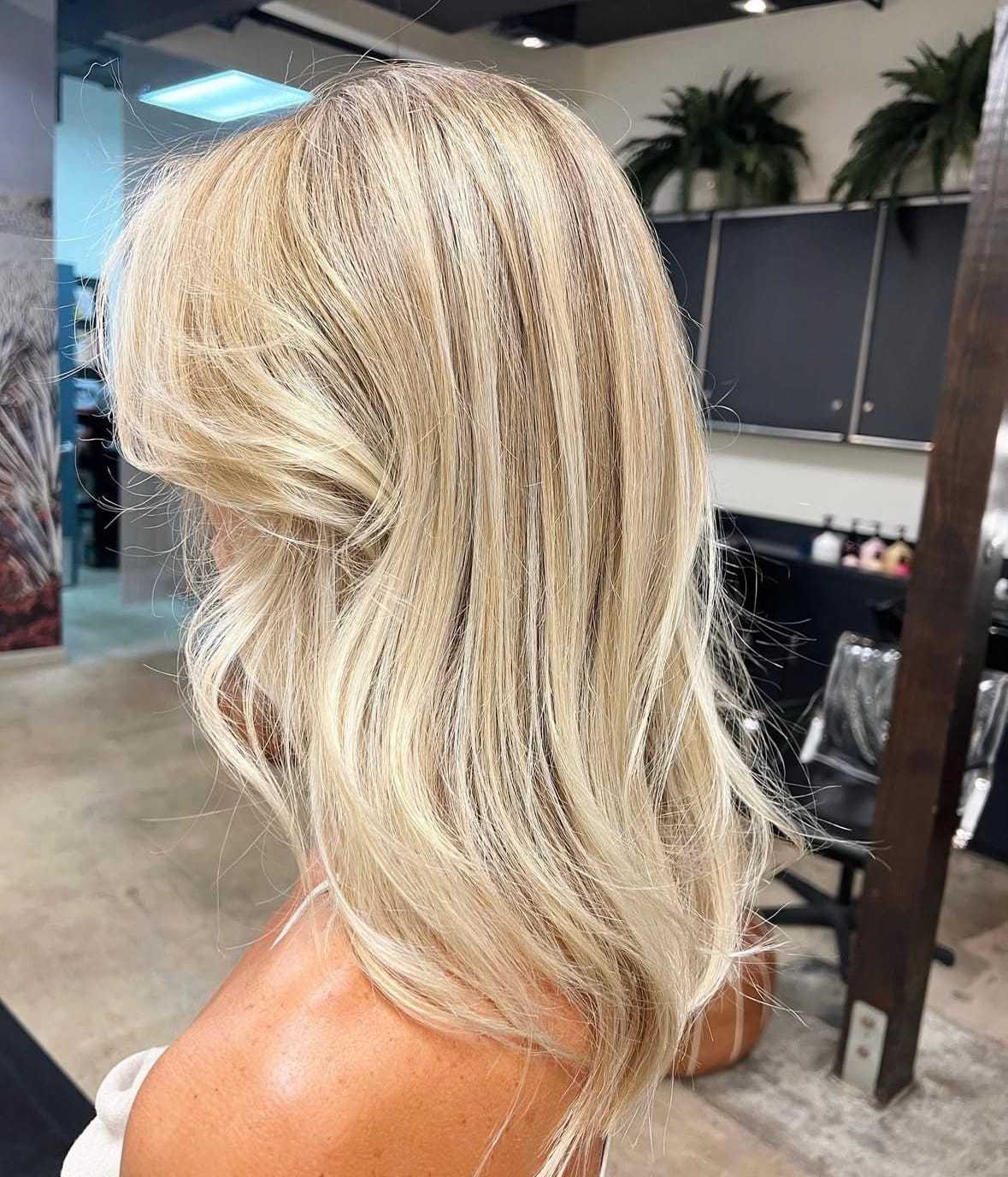 Blonde hair styled in soft waves at a modern salon.